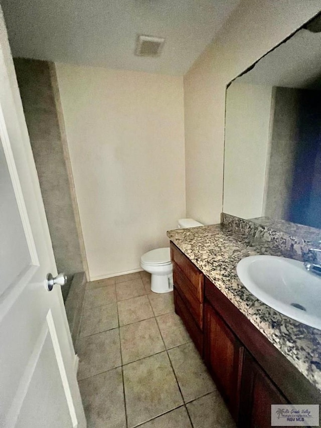 bathroom featuring tile patterned floors, vanity, and toilet