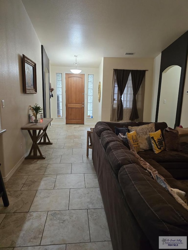 living room featuring baseboards and visible vents