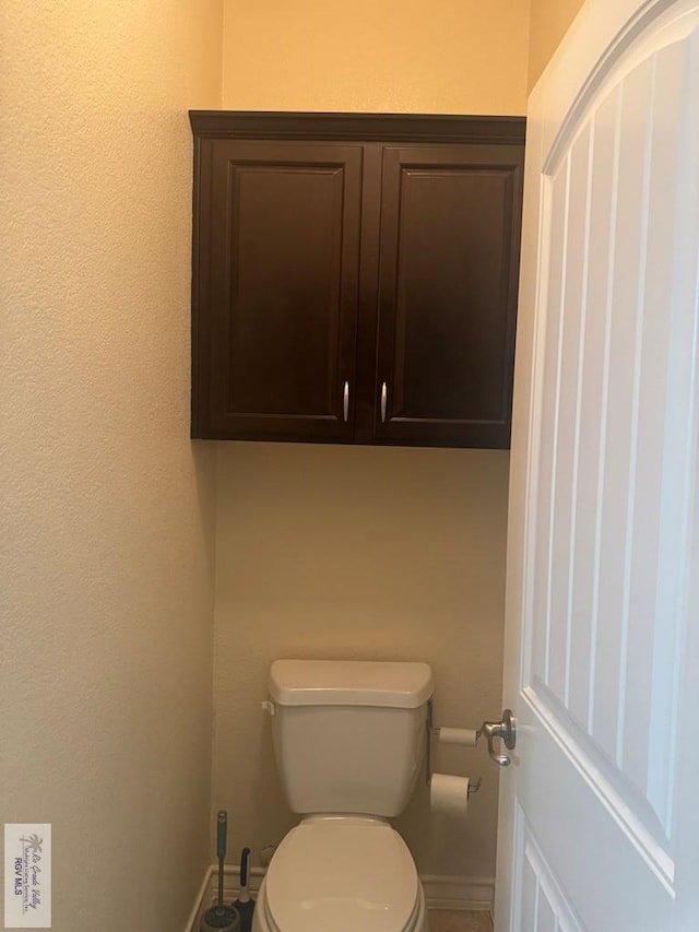 bathroom featuring toilet and baseboards