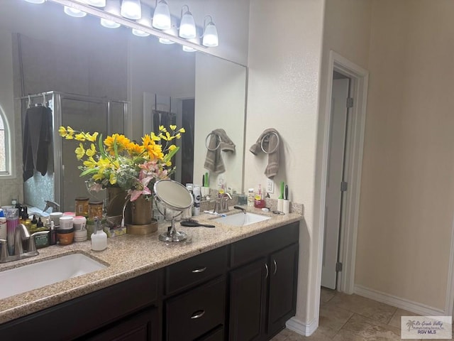 bathroom featuring double vanity, tile patterned flooring, a stall shower, and a sink