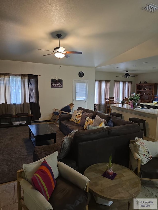 living area featuring visible vents and ceiling fan