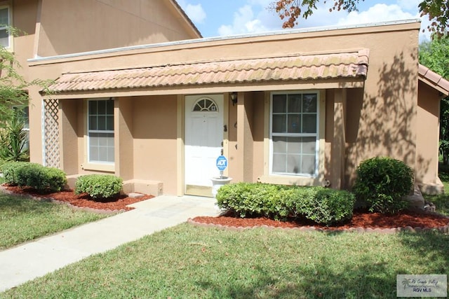 view of exterior entry with a lawn