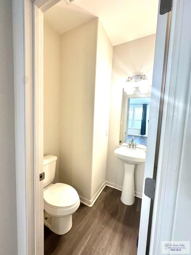 bathroom featuring hardwood / wood-style flooring and toilet