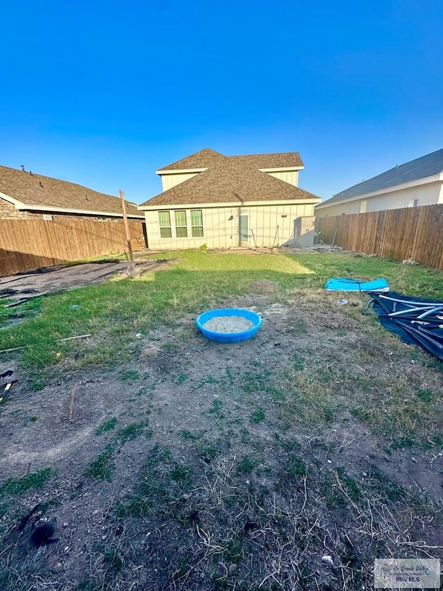 rear view of property featuring a lawn