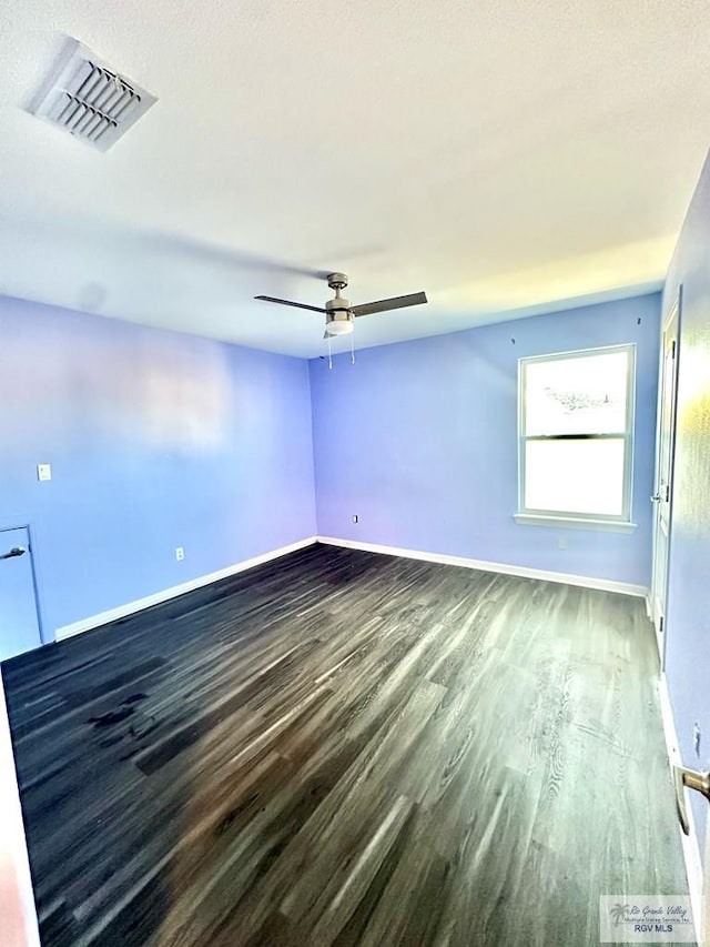 spare room featuring dark wood-type flooring and ceiling fan