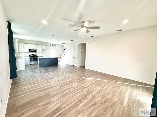 unfurnished living room with light wood-type flooring and ceiling fan