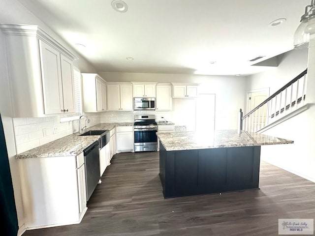 kitchen with white cabinets, light stone countertops, and stainless steel appliances