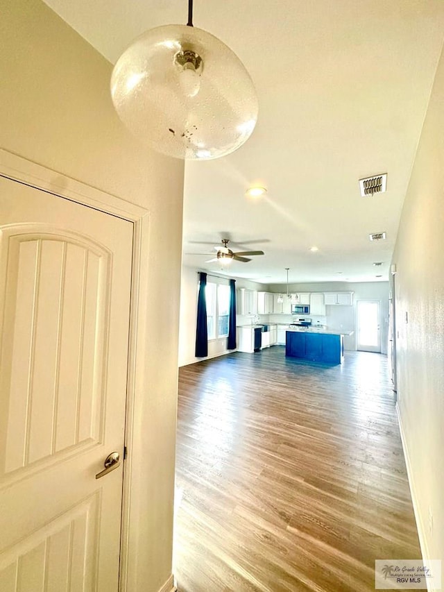 unfurnished living room featuring ceiling fan and hardwood / wood-style floors