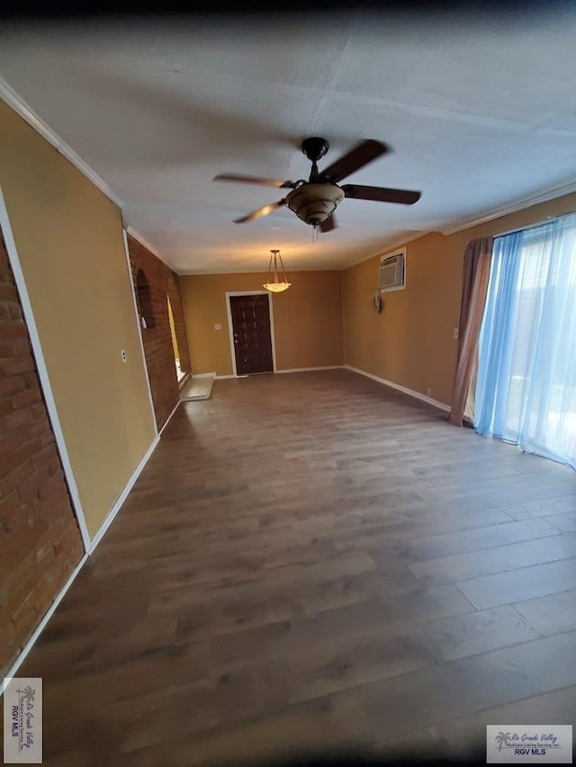 unfurnished living room featuring ornamental molding, a wall mounted AC, a ceiling fan, and wood finished floors