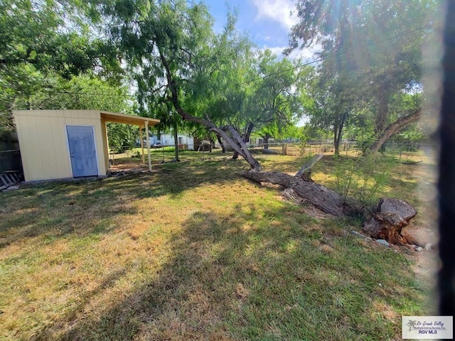 view of yard with a shed, an outdoor structure, and fence