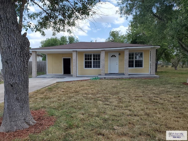 single story home with a front yard, fence, driveway, covered porch, and a carport