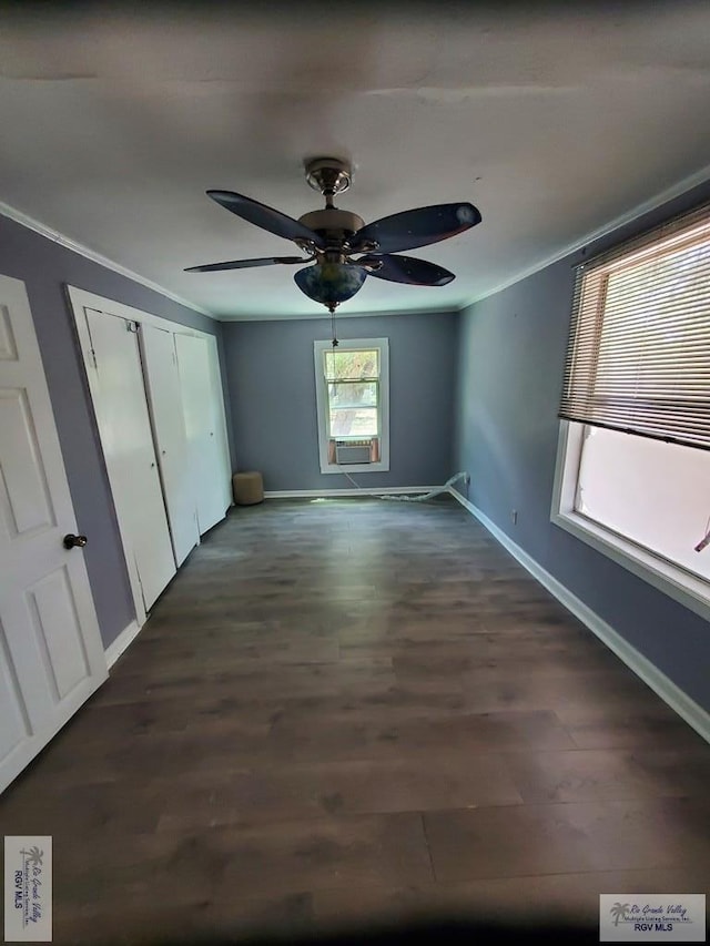 unfurnished bedroom with dark wood finished floors, crown molding, and baseboards
