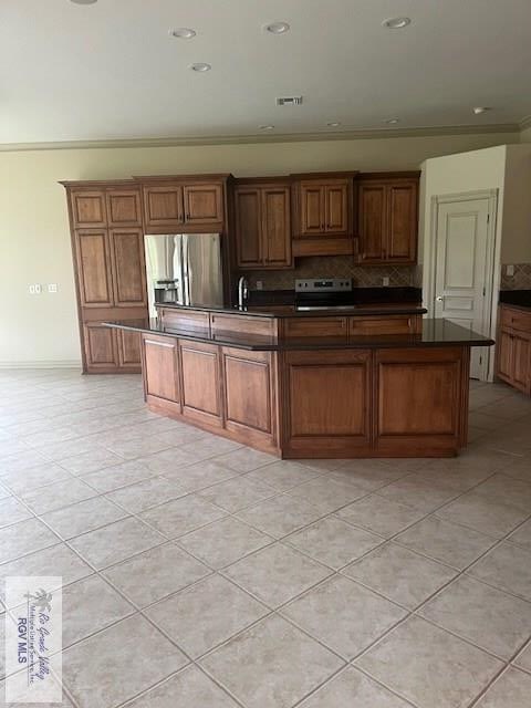 71 Cortez Ave, Rancho Viejo, TX 78575 - kitchen featuring stainless steel appliances, dark countertops, and light tile patterned floors
