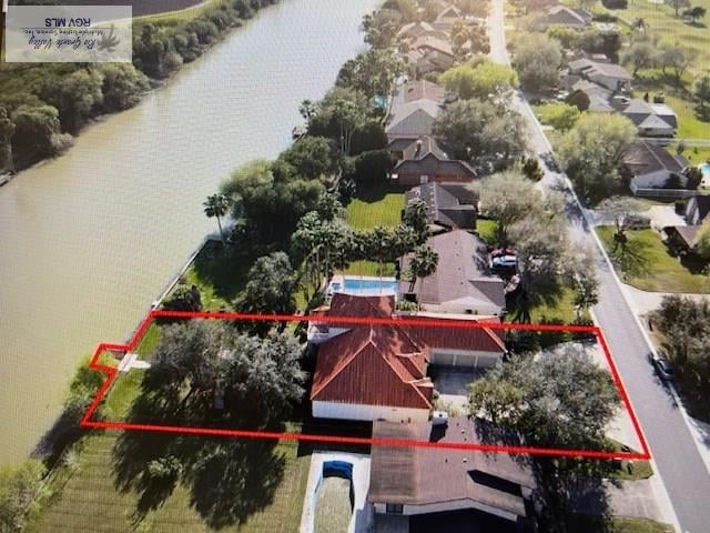 71 Cortez Ave, Rancho Viejo, TX 78575 - aerial perspective of suburban area with property parcel outlined and a nearby body of water