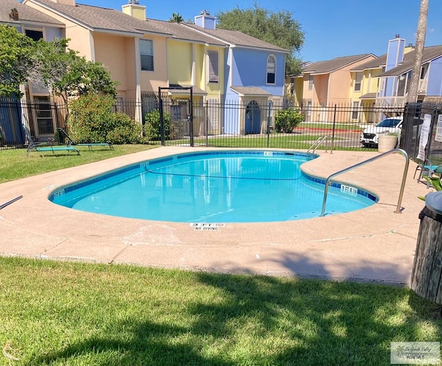 community pool with a yard, a residential view, and fence