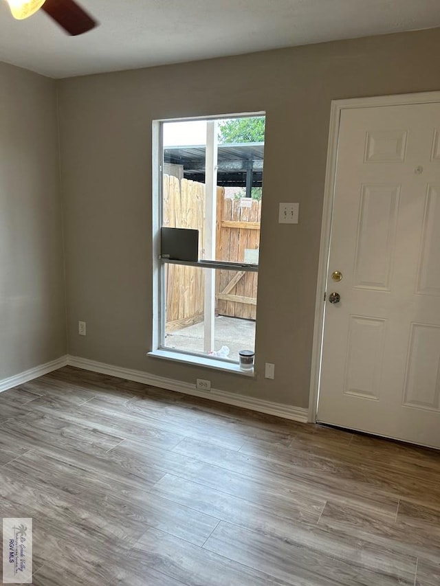 unfurnished room featuring ceiling fan, baseboards, and wood finished floors