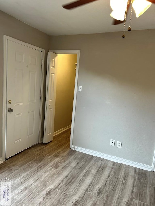 unfurnished room with light wood finished floors, ceiling fan, and baseboards