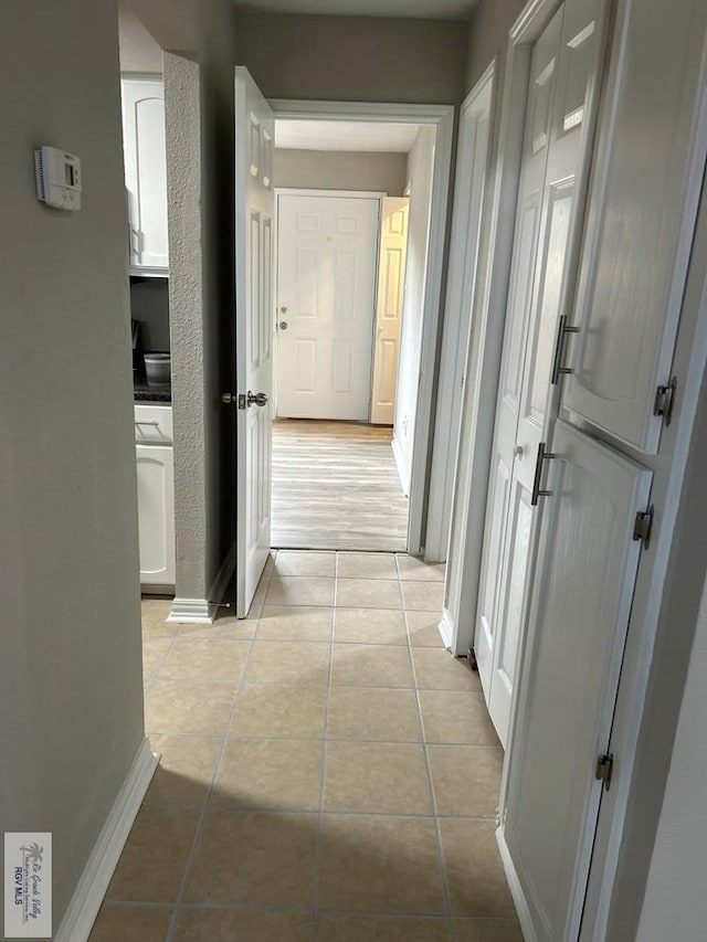 hall with light tile patterned floors and baseboards