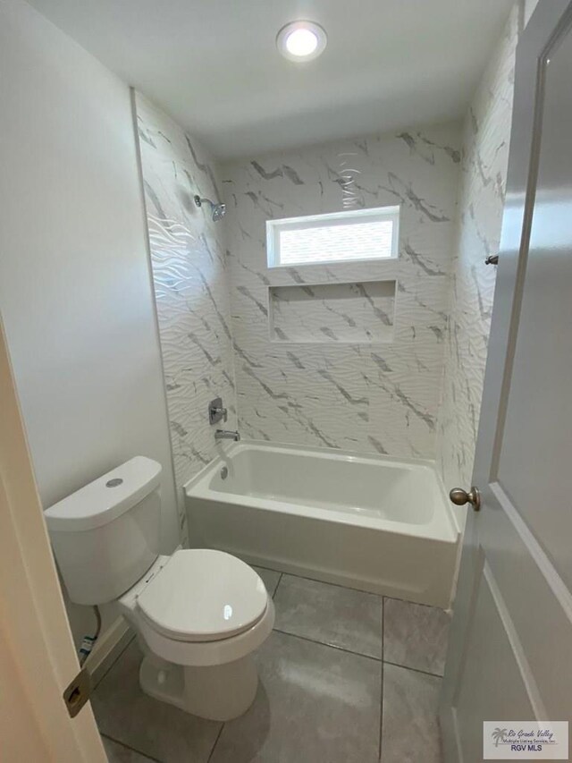 bathroom featuring tile patterned floors, toilet, and tiled shower / bath