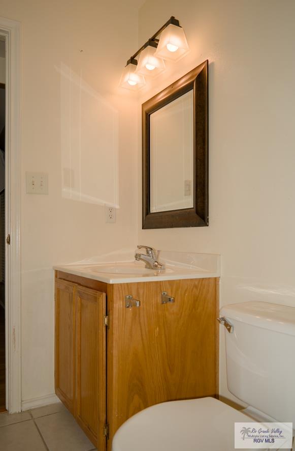 bathroom featuring tile patterned floors, vanity, and toilet