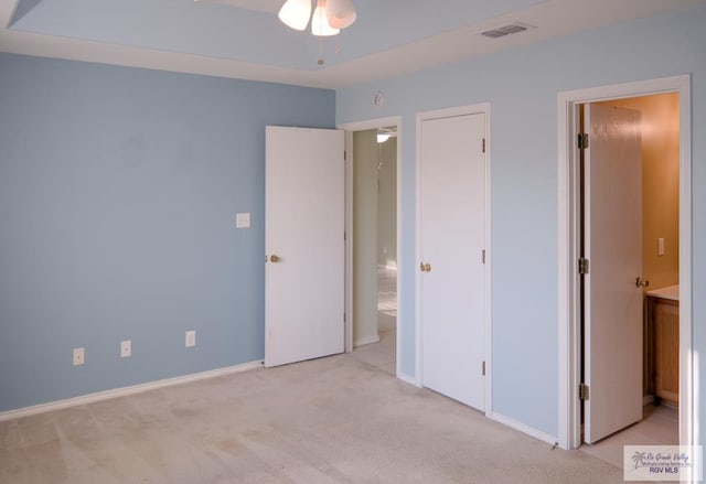 unfurnished bedroom with light carpet and connected bathroom