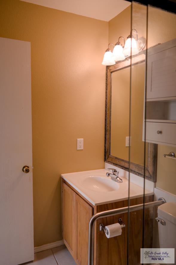 bathroom featuring tile patterned flooring, vanity, and toilet