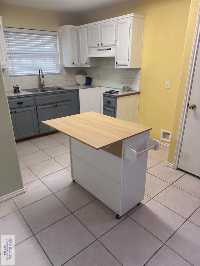 kitchen featuring gray cabinetry, sink, decorative backsplash, light tile patterned floors, and white cabinetry