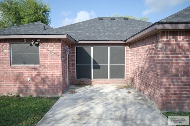 view of exterior entry with a patio area