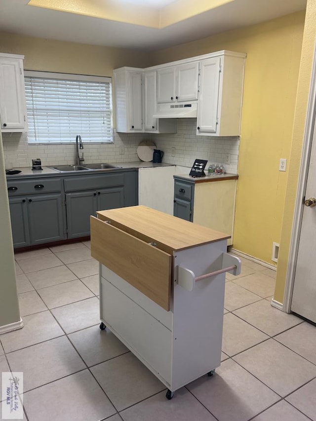 kitchen featuring gray cabinets, sink, white cabinets, and light tile patterned flooring