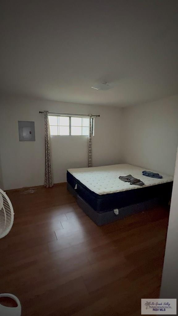 bedroom featuring dark hardwood / wood-style flooring and electric panel