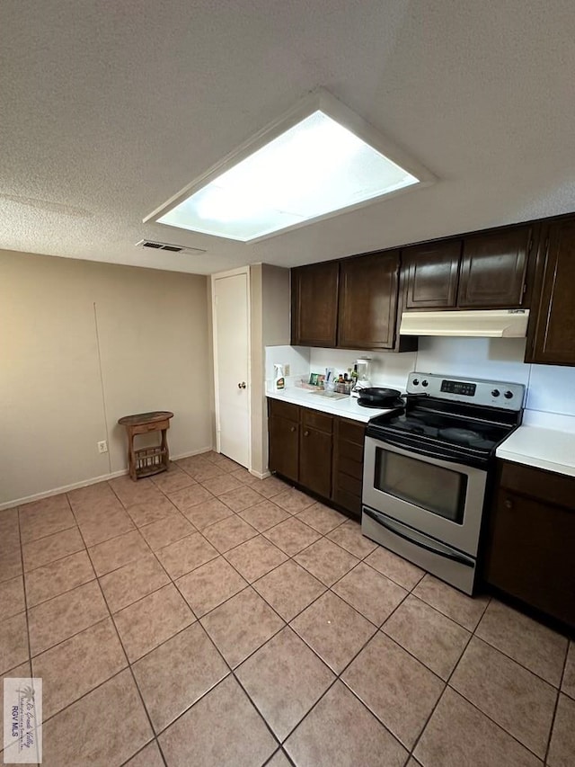 kitchen featuring dark brown cabinetry, electric stove, a textured ceiling, and light tile patterned floors