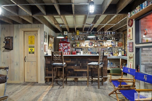 bar featuring wood-type flooring and wooden walls