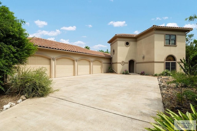 mediterranean / spanish home featuring a garage