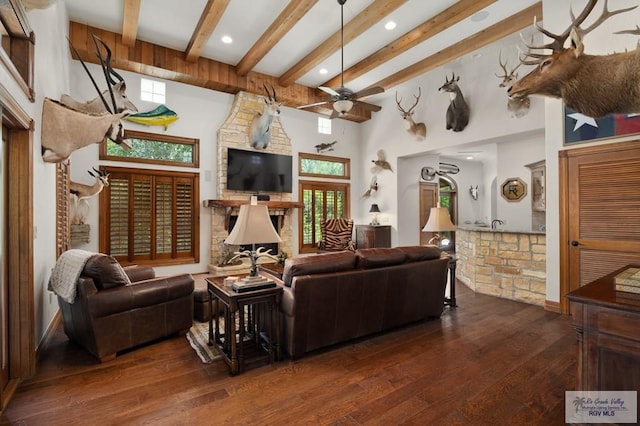 living room with ceiling fan, plenty of natural light, and dark wood-type flooring