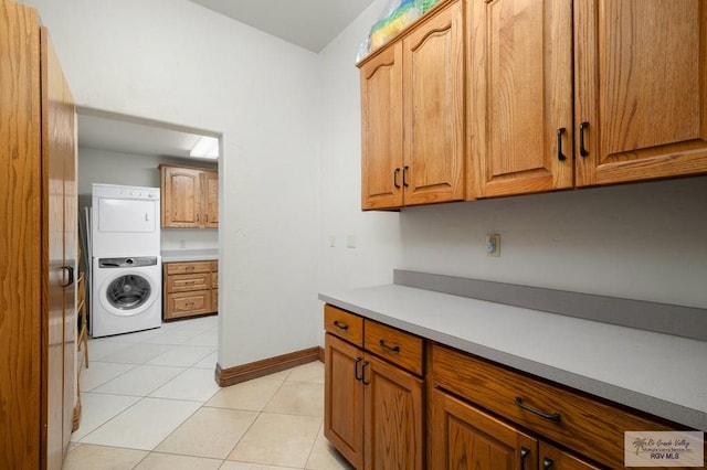 kitchen featuring stacked washer and clothes dryer and light tile patterned flooring