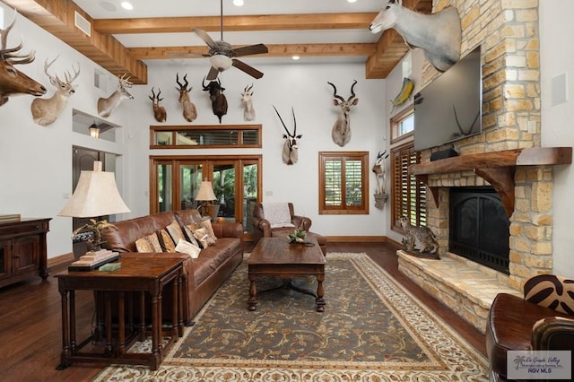 living room featuring beam ceiling, dark hardwood / wood-style floors, and plenty of natural light