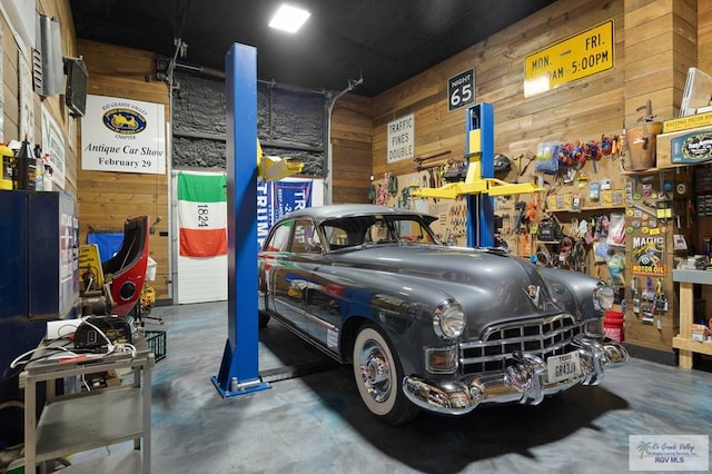 garage featuring a workshop area and wood walls