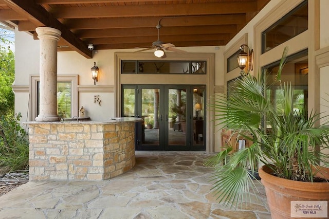 property entrance with area for grilling, ceiling fan, french doors, and exterior bar