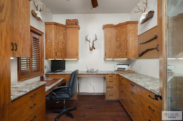 office featuring ceiling fan, built in desk, and dark hardwood / wood-style floors