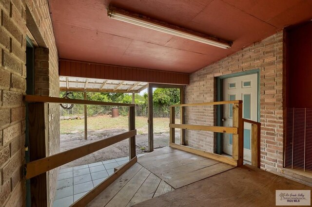 unfurnished sunroom featuring vaulted ceiling