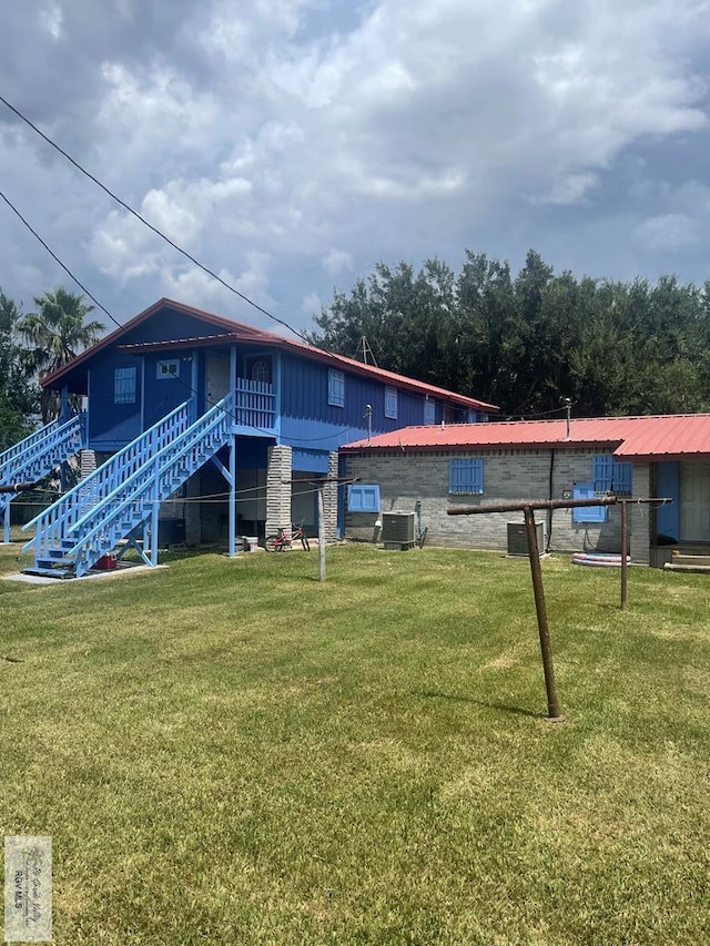 back of property featuring a sunroom, a yard, and central air condition unit