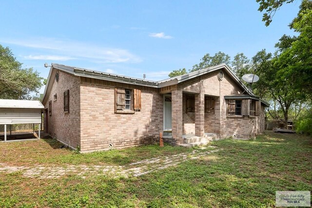 view of front of house with a front lawn and a carport