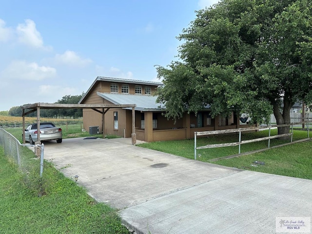 view of front of house featuring cooling unit, a front lawn, and a carport