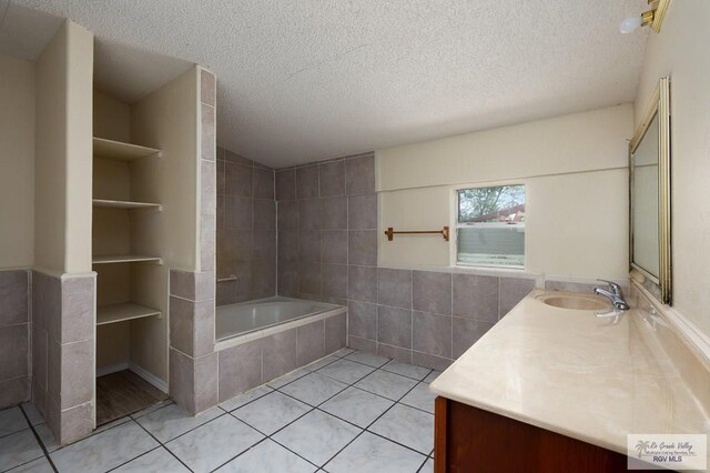 bathroom featuring built in features, tile patterned flooring, vanity, and a textured ceiling