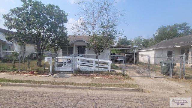 909 W Hanson St, Harlingen, TX 78550 - view of front facade with a gate, a fenced front yard, a carport, and concrete driveway