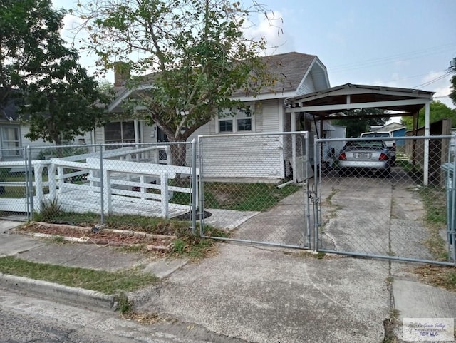 909 W Hanson St, Harlingen, TX 78550 - view of front facade featuring a gate, a fenced front yard, a chimney, and concrete driveway