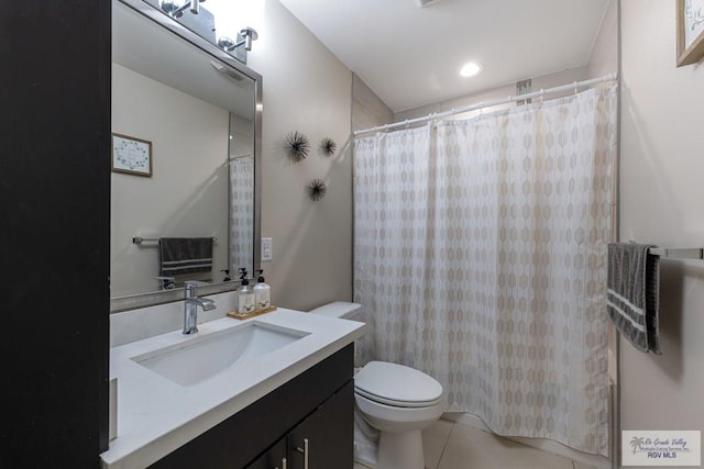 bathroom with vanity, tile patterned floors, toilet, and walk in shower