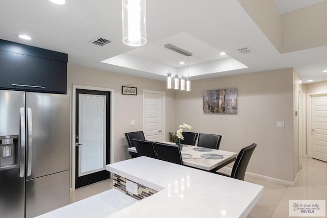 home office featuring a tray ceiling and light tile patterned flooring