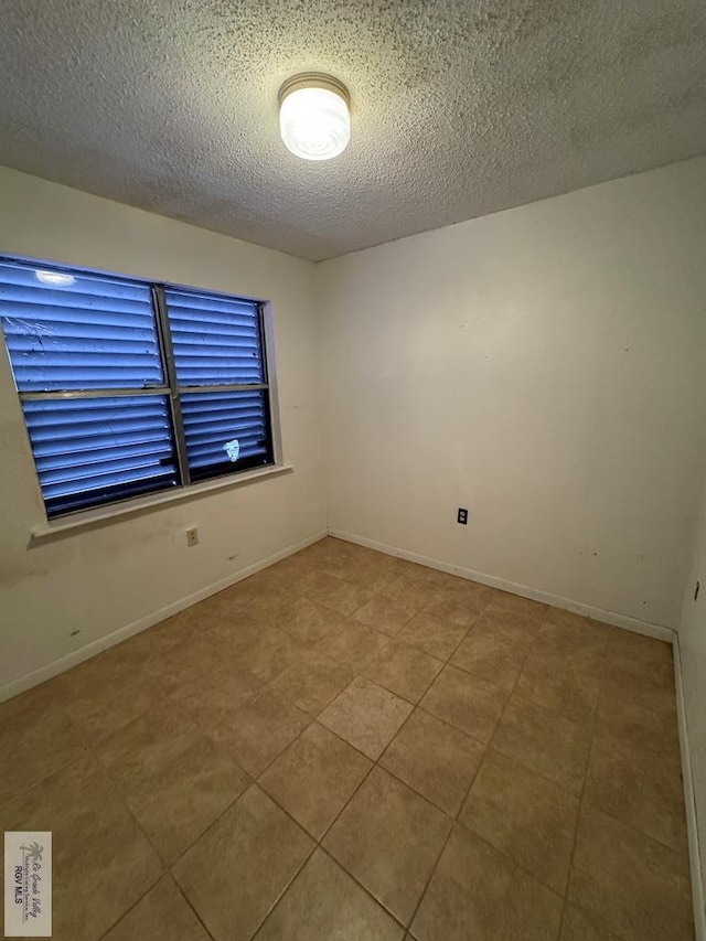 25631 N White Ranch Rd, La Feria, TX 78559 - empty room with a textured ceiling and tile patterned flooring
