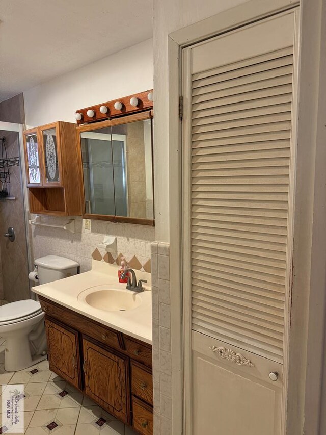 25631 N White Ranch Rd, La Feria, TX 78559 - bathroom featuring vanity, tile patterned flooring, a shower with door, a closet, and tile walls